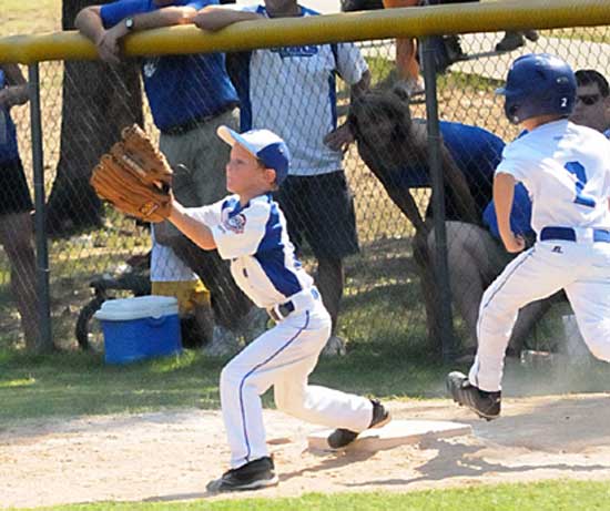 C.J. Nagle stretches for a throw at first as a Sylvan Hills runner approaches the bag. (Photo by Kevin Nagle)