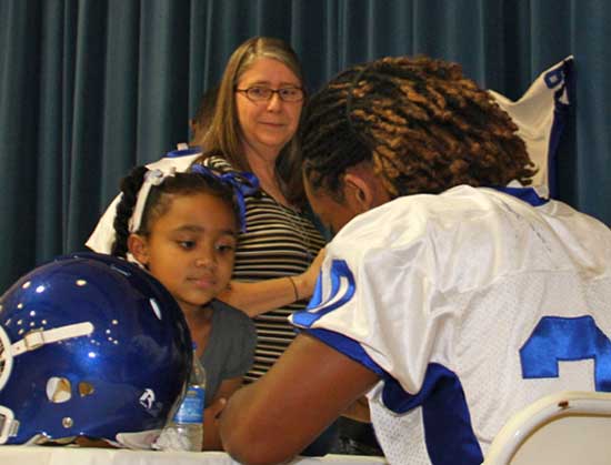 A young Hornets fan gets an autograph from junior running back Jalen Bell. (Photo by Rick Nation)