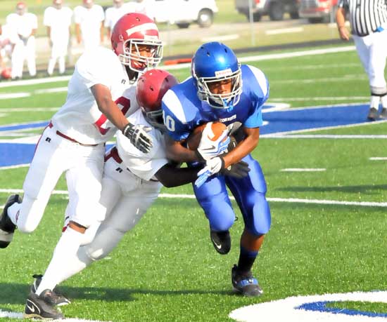 Steven Murdock is dragged down by a pair of Pine Bluff players after catching a pass. (photo by Kevin Nagle)