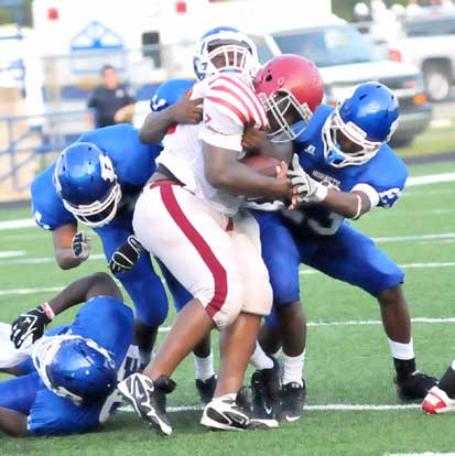 Bryant's Chris Stephens (21) and Travis Royal (23) try to wrestle down Pine Bluff fullback Xavier Roaf. (Photo by Kevin Nagle)