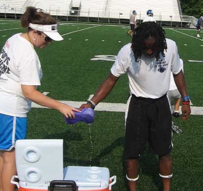 Trainer Christa Finney takes an ice sponge from senior Dillon Winfrey.