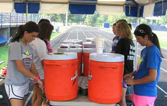 Student trainers prepare for a water break during football practice on Wednesday morning. 