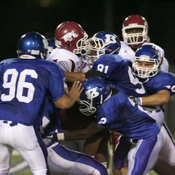 Tim Kelly (91), Dillon Winfrey (2), Austin Dunahoo (96) and others pile up a Texarkana ballcarrier. (Photo by Rick Nation)