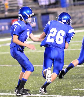 Madison Schrader (7) hands off to Hunter Lawhon. (Photo by Kevin Nagle)