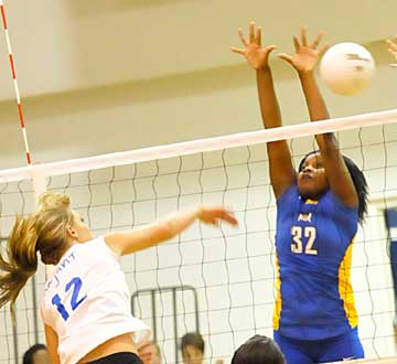 McKenzie Rice, left, makes a bid for one of her 18 kills. (Photo by Kevin Nagle)