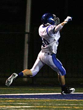 Bryant's Drew Tipton raises his arms as he scores on an interception return. (Photo by Rick Nation)