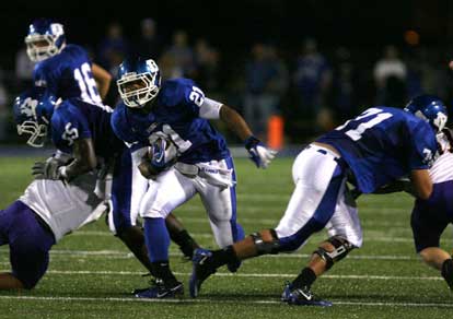 Ben Clark (21) runs through a hole provided by Cortez Williams (65) and Blain Jackson (71) (Photo by Rick Nation)
