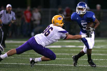 Karon Dismuke stiff-arms Catholic tackler Hayden Carman. (Photo by Rick Nation)
