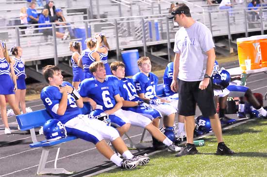 Coach Jason Hay visits with Wesley Akers (9), Austin Powell (6), Jacob Irby (19) and Austin Vail (25). (Photo by Kevin Nagle)