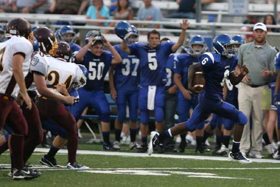 K.J. Hill runs past his teammates on the sideline on a 43-yard punt return for a touchdown. (Photo by Rick Nation)