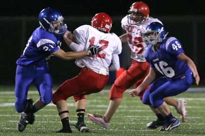 Ben Bruick (21) pulls down Cabot South quarterback Jonathan Gilleylan as Kyle Lovelace (46) arrives to help. (Photo by Rick Nation)