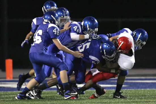 Rashaan Jones (55), Matt Shiew (42), Kyle Lovelace (46) lead a swarm of Hornet defenders. (Photo by Rick Nation)