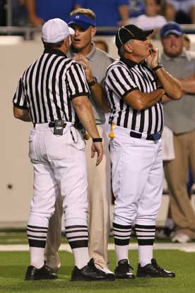 Head coach Paul Calley discusses a call with the lead official while another stands guard. (Photo by Rick Nation)