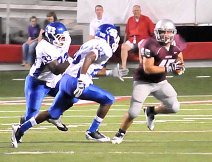 Bryant's Tyree Reese (33) and Travis Royal (23) chase down Benton punter Carson Holloway. (Photo by Kevin Nagle)