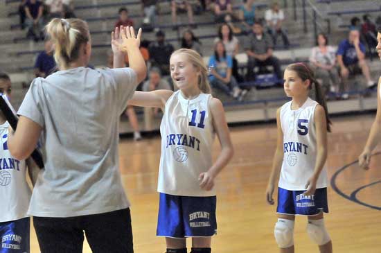 Bryant White coach DeAnna Ward gives Reagan Blend a high five during a break in Tuesday's action as Breanna Hall (5) follows to the bench. (Photo by Kevin Nagle)