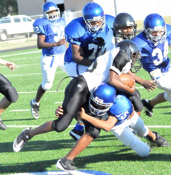 Kameron Guillory (35) makes a tackle as teammates Cameron Murray (72), Devon Alpe (34) and Demaja Price (32) pursue. (photo by Kevin Nagle)