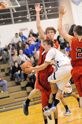 Brantley Cozart gets bumped around as he drives to the bucket. (Photo by Kevin Nagle)