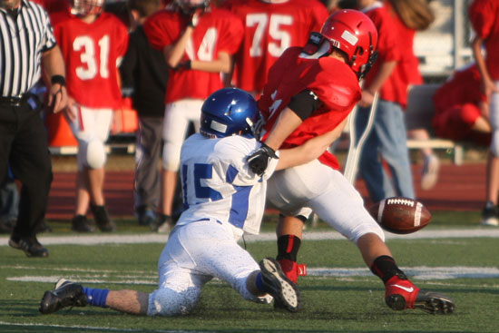 Collin Welch (15) jars the ball loose from Cabot North running back Cody Nabors. (Photo by Rick Nation)