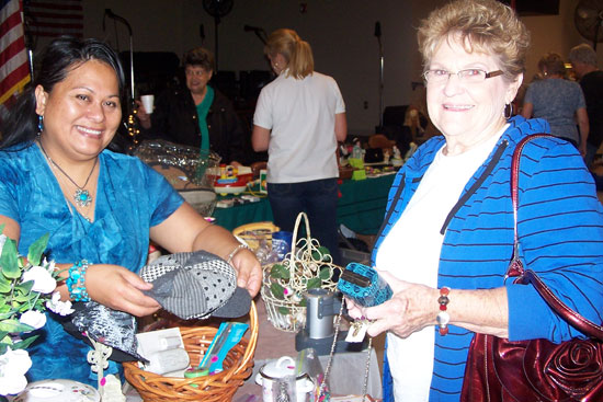 From left, Maria Evans, a vendor at the Bryant Senior Center Market Day, assists customer Guyva Thomas of Bryant with items for sale. Proceeds from Market Day benefitted the Bryant Senior Center meals for seniors program.