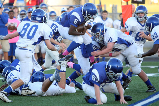 Bryant Blue running back Phillip Isom-Green leaps over the pile to try to pick up extra yardage. (Photo by Rick Nation)