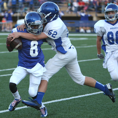 Bryant White's Joe Small (52) hits Bryant White quarterback Desmond Duckworth (8) as Garrett Misenheimer (80) arrives. (Photo by Rick Nation)