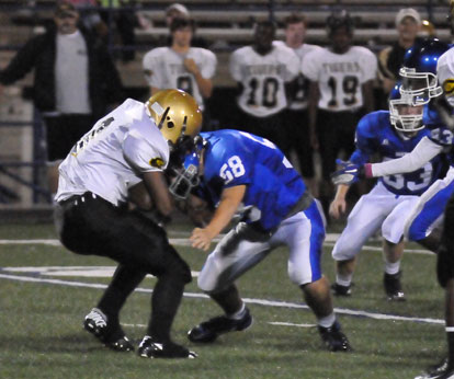 Jacob Hall (58) hits Central running back Richard Hayes. (Photo by Kevin Nagle)