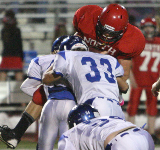 Bryant's Khaliq Slater and Drew Alpe (33) lift a Cabot North player off his feet making a tackle in a recent game. (Photo by Rick Nation)