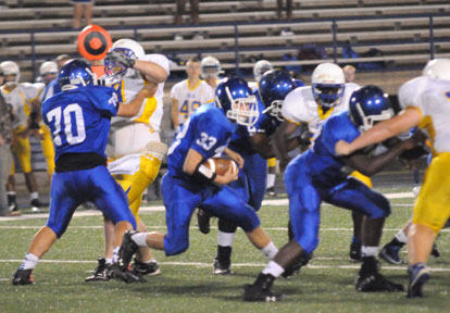 Drew Alpe (33) cuts behind blocks from Zach Jackson (70), Cameron Murray and Demaja Price (right). (Photo by Kevin Nagle)