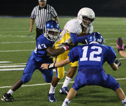 Khaliq Slater (43) grabs on and Evan Lee (12) prepares to help out. (Photo by Rick Nation)