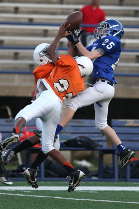 Jesse Smith (25) leaps high for a pass against a pair of Ridge Road defenders. (Photo by Rick Nation)