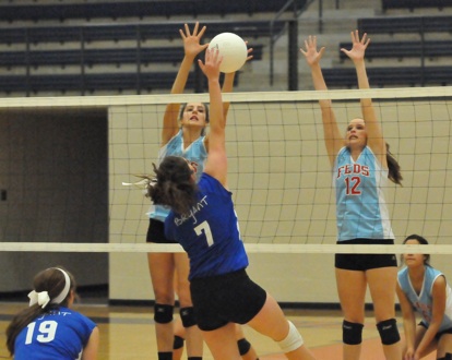 Courtney Davidson (7) attacks against a pair of Lady Rebels. (Photo by Kevin Nagle)