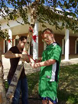 A pair of Springhill fourth graders tie red ribbons on a tree outside the school.