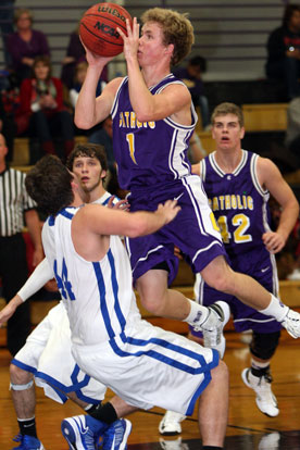 Bryant's Zach Cambron, left, takes a charge, one of three on the night, as Catholic's Sam Greenwood drives to the basket. (Photo by Rick Nation)