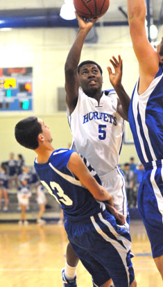 Kris Croom (5) throws up a shot between a pair of Conway White players. (Photo by Kevin Nagle)
