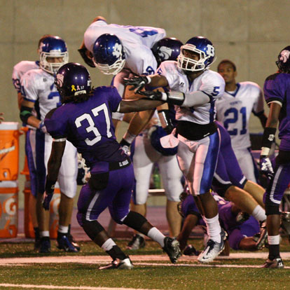 Bryant's Nate Rutherford (88) goes airborne to pick up extra yardage as K.J. Hill blocks. (Photo by Rick Nation)