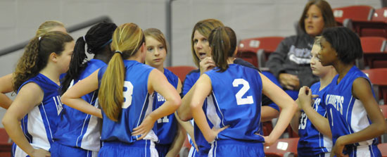 Bryant Blue head coach Rhonda Hall huddles with her team during a timeout in Monday's opener. (Photo by Kevin Nagle)