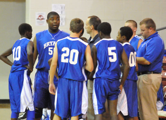 Head coach Mike Simmons and assistant Brett Haugh huddle with the Hornets during a timeout. (Photo by Kevin Nagle)
