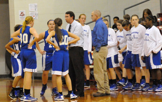 Bryant coaches Nathan Castaldi and Lawrence Jefferson huddle up with the team during a timeout. (Photo by Kevin Nagle)