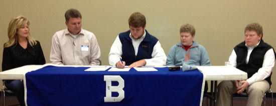 Austin Harmon signs his letter of intent with Central Baptist College with his parents Richard and Linda and twin brothers Tanner and Taylor.