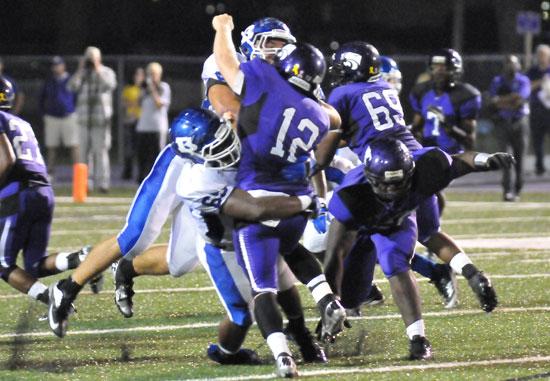 Kordell Boykins (65) and Tim Kelly (91) hit El Dorado quarterback Lucas Reed (12) as he releases a pass. (Photo by Kevin Nagle)