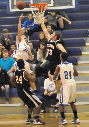 Bryant's Ryan Hall (34) goes up for a shot in front of a Russellville defender and teammate Jaylen Peterson (24). (Photo by Kevin Nagle)