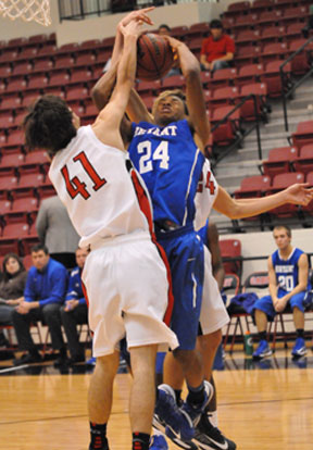 Jaylen Peterson (24) gets a shot blocked in front and a slap on the head from behind. (Photo by Kevin Nagle)