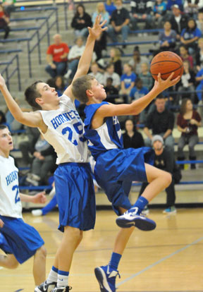 Bryant Blue's Sam Chumley goes up for a shot in front of Bryant White's Tristan Calhoun. (Photo by Kevin Nagle)