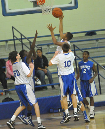 Romen Martin goes up for a layup in front of Kyle Sahr (50), Jake East (10) and Desmond Duckworth (2). (Photo by Kevin Nagle)