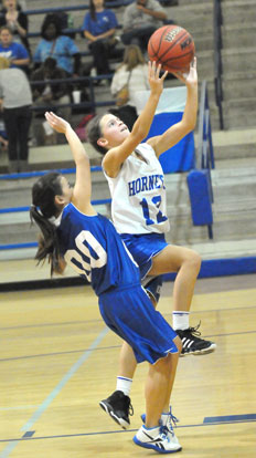 Maddie Stephens (12) goes up for a shot as Cadie Anderson defends. (Photo by Kevin Nagle)