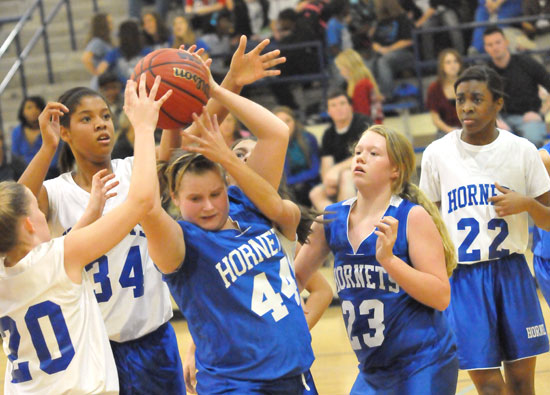 Bryant Blue's Stephanie Cullen (44) secures a rebound in a crowd including teammate BAylee Rowton and Bryant White's Maddie Miller (20), Raven Loveless (34) and Jaylen Sparks (22) during Monday night's game. (Photo by Kevin Nagle)