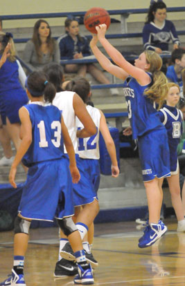 Bryant Blue's Baylee Rowton launches a shot in front of teammate Raija Todd (13) and Bryant White's Raven Loveless and Maddie Stephens (12). (Photo by Kevin Nagle)