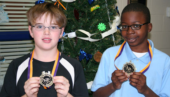 Miles Burgess and Nnume Nwankwo show the awards earned in the Noetic Math competition.