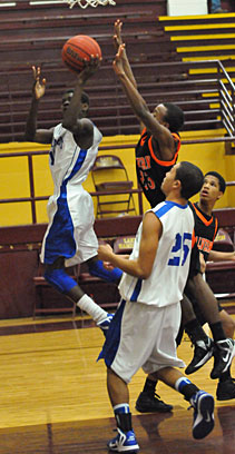 Kevin Hunt reaches back for a shot as teammate Jaelynn Jones (25) follows the play. (Photo by Kevin Nagle)