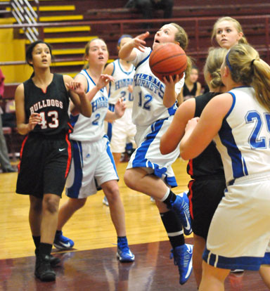 Skylar Davis drives to the basket as teammates Anna Turpin (25) and Britney Sahlmann gets into rebounding position. (Photo by Kevin Nagle)